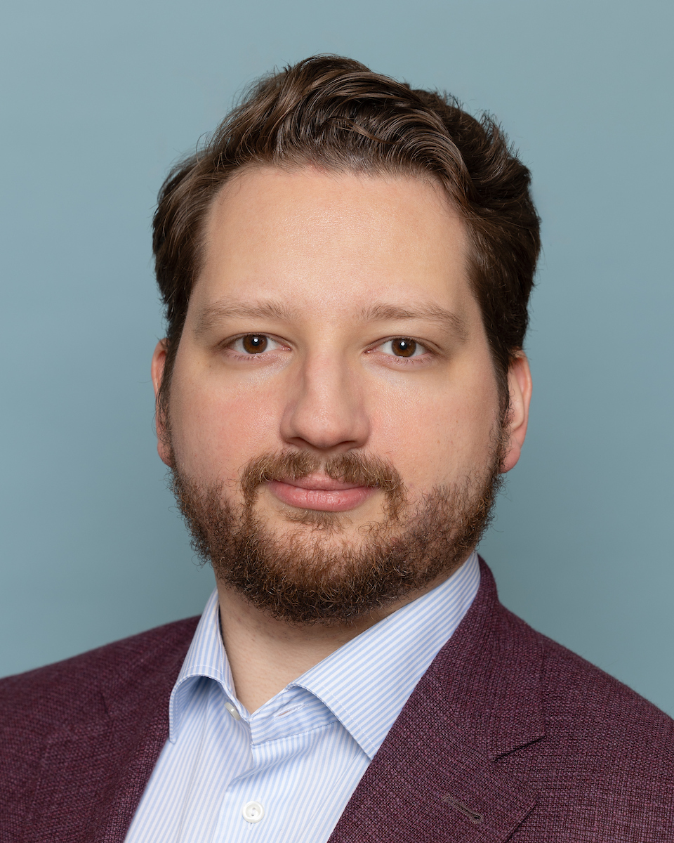 Business headshot of man against pale blue background by Montreal headshot photographer Julian Haber