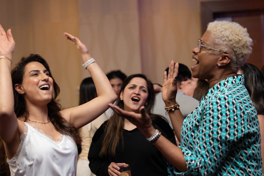 Brother24-NatCon - Credit Julian Haber-20240508-602A0155 Three women throwing their arms up in the air having a really good time while dancing together, photographed by event photographer, Julian Haber in Montreal.