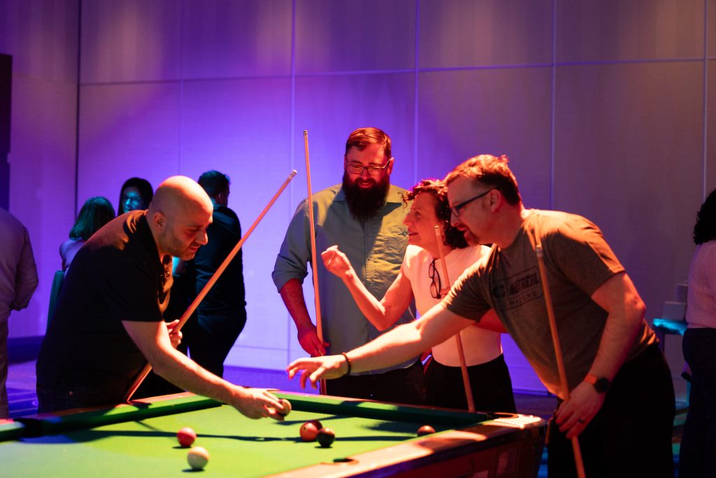 Brother24-NatCon - Credit Julian Haber-20240508-602A0217 Two men and a woman playing pool, photographed by event photographer, Julian Haber in Montreal.