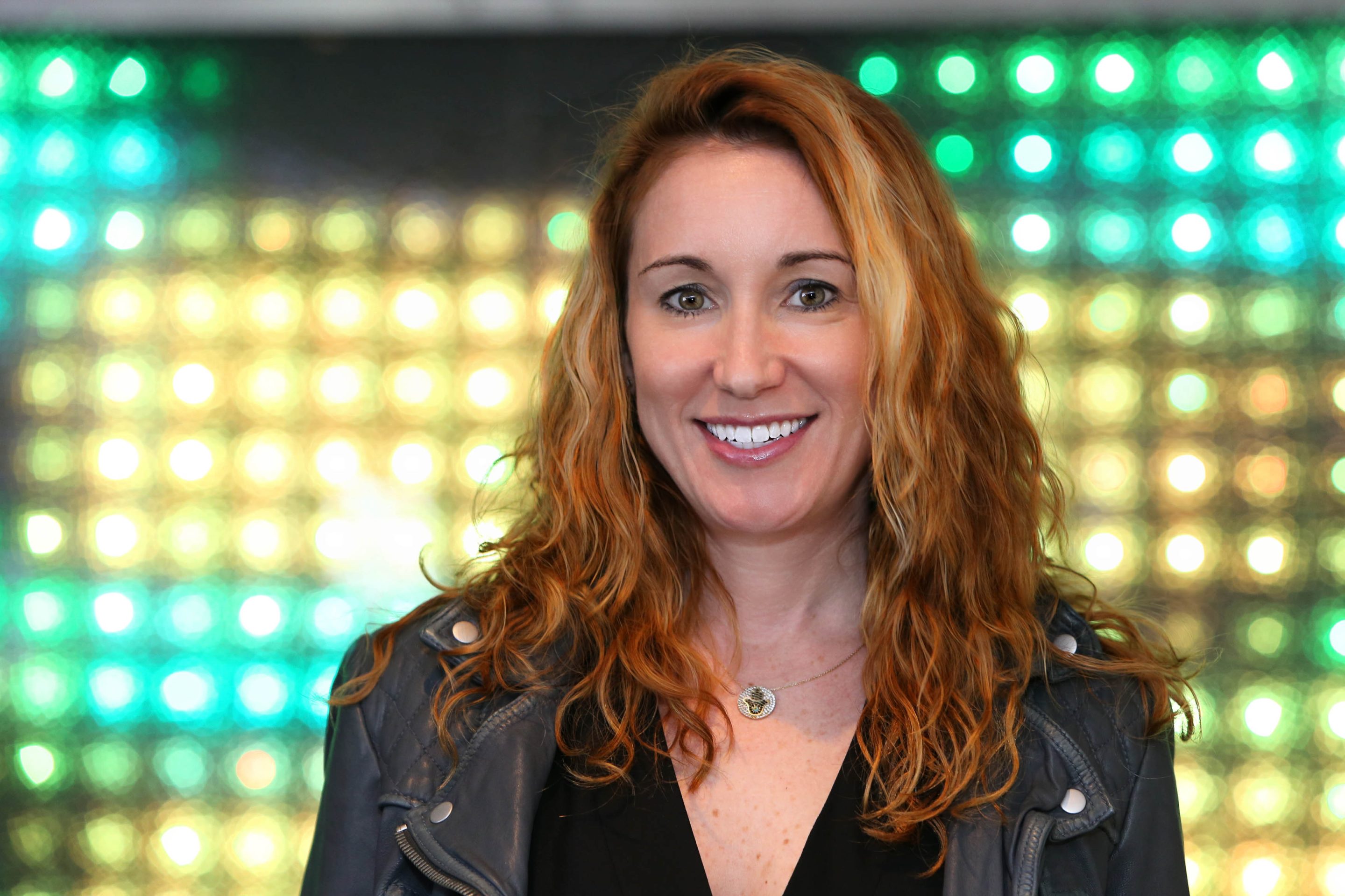 Professional woman in front of colourful LED background