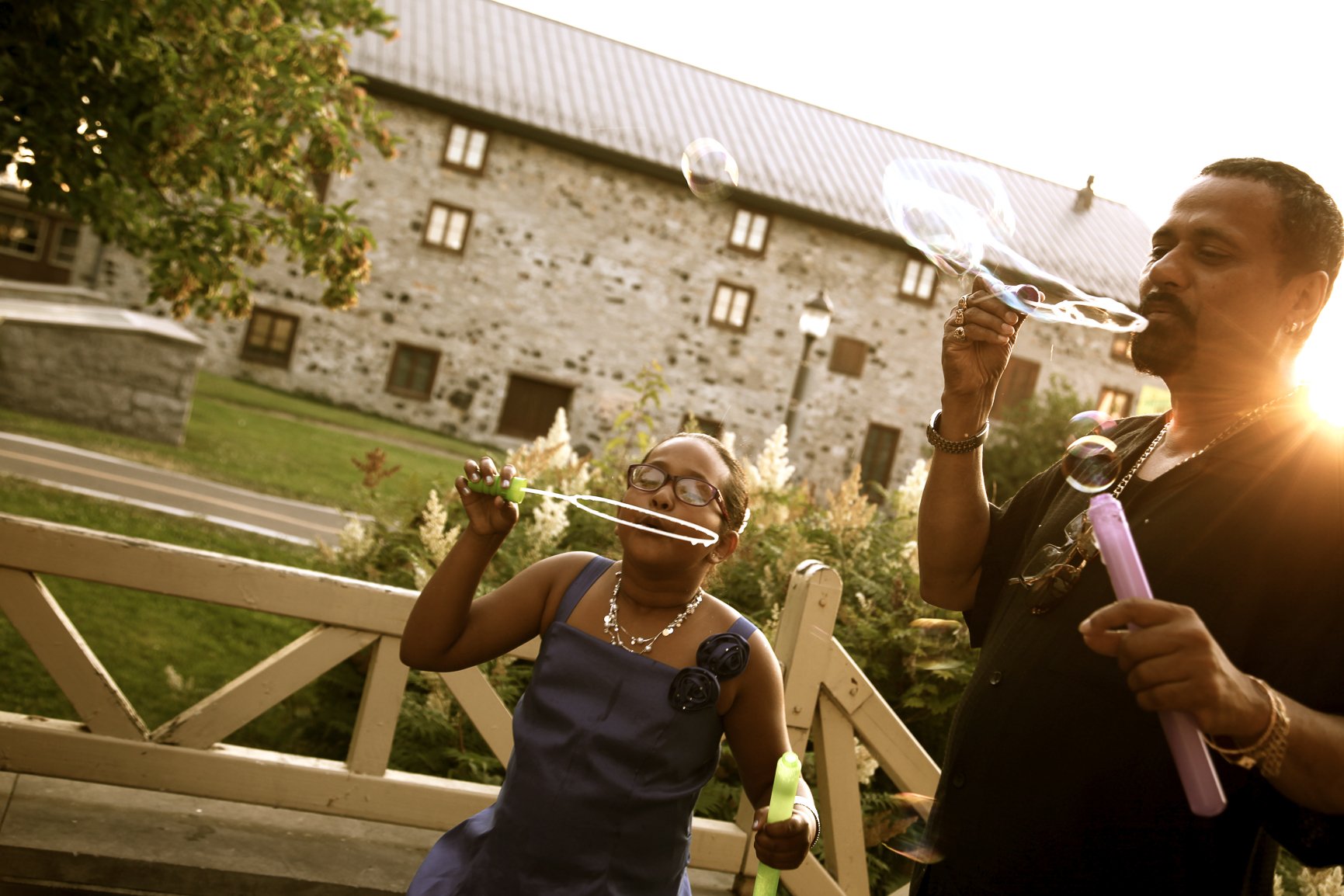 CREDIT Julian Haber-20140705 Father and daughter blowing bubbles backlit by sun