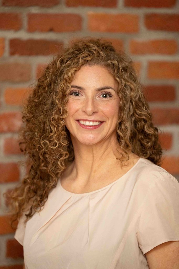 CREDIT Julian Haber-JEN-MCGRATH-20240823-AA8A0504 Smiling professional in a relaxed setting in front of brick wall