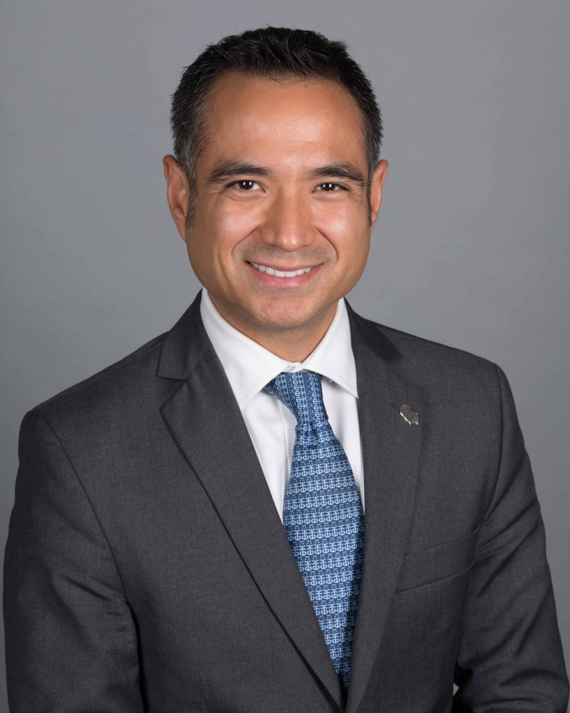 CREDIT Julian Haber-SMILE-20191112-_94A1475-Edit Professional portrait of latin business man wearing blue tie and suit jacket with a large smile