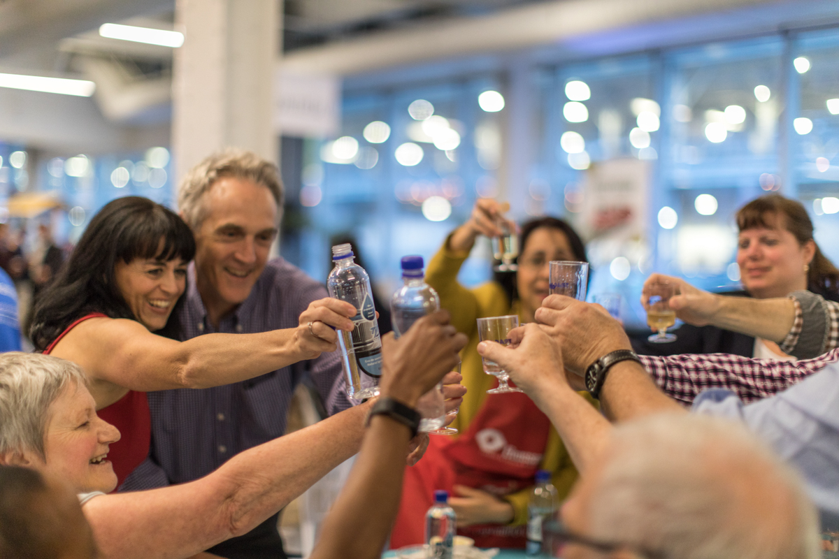 corporate-event-guests-toasting-montreal-photography Guests raising a toast during a joyful networking celebration at a Montreal event by Julian Haber.