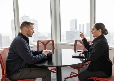 Employer branding photography by Julian Haber at Fednav Montreal, showing a team meeting with the downtown city skyline in the background.