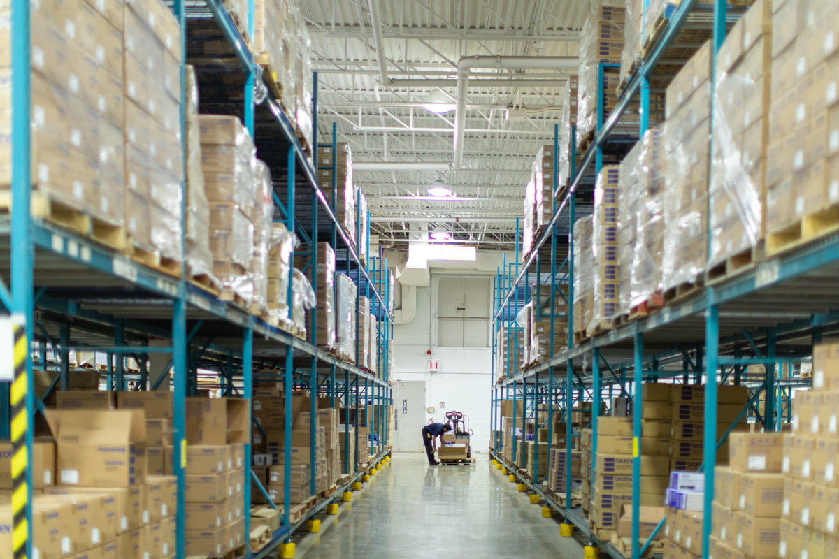 julian-haber-photography-employer-branding-montreal-28 Architectural symmetry of a large industrial warehouse with high-shelf storage racks by Julian Haber